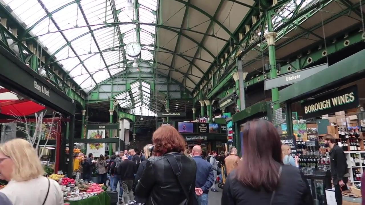 Shoppers beneath Borough Market’s glazed roof and green ironwork.