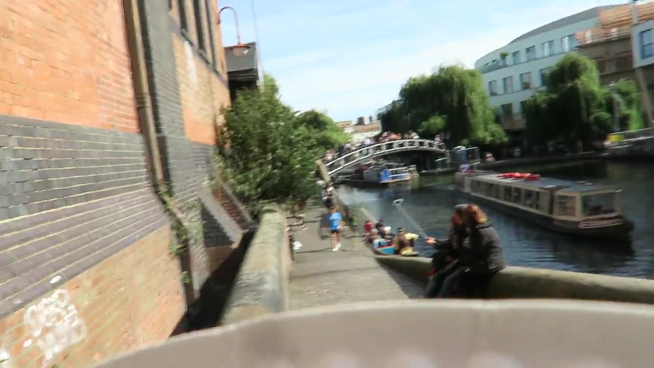 People sitting beside the canal near Camden Lock on a sunny day