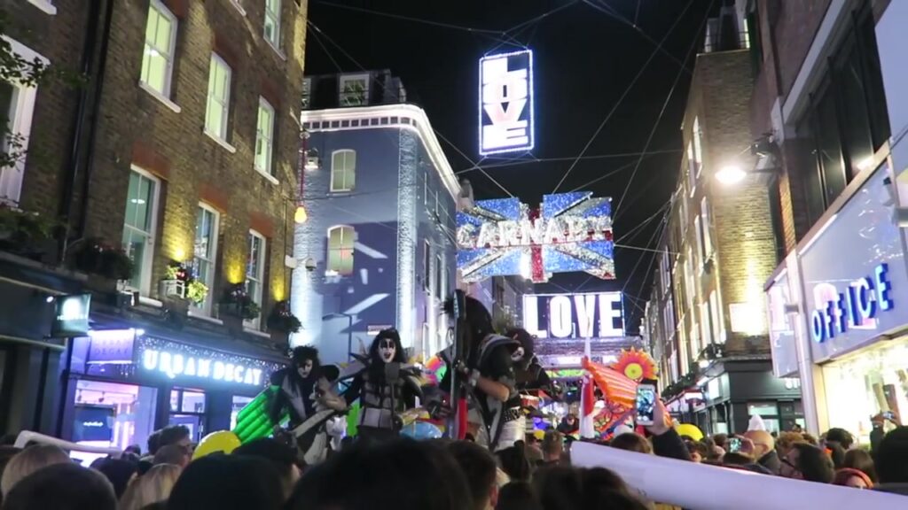 Carnaby and Love signs above colourful street performers in 2016