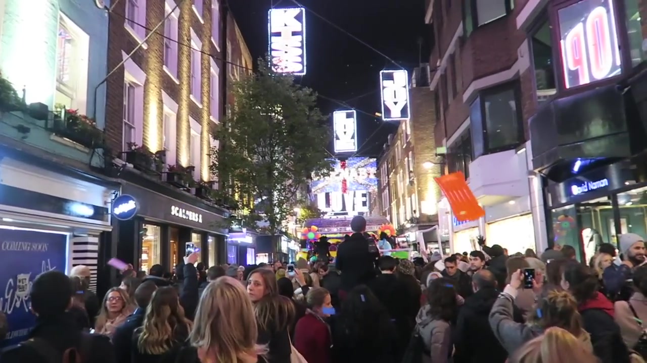 Crowds and performers beneath the Christmas lights on Carnaby Street