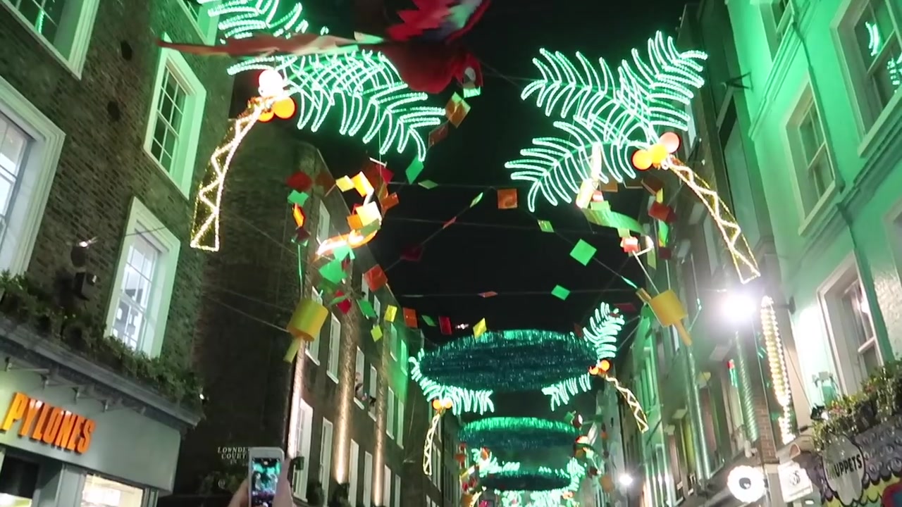 Illuminated green palm leaves and colourful decorations above Carnaby Street.