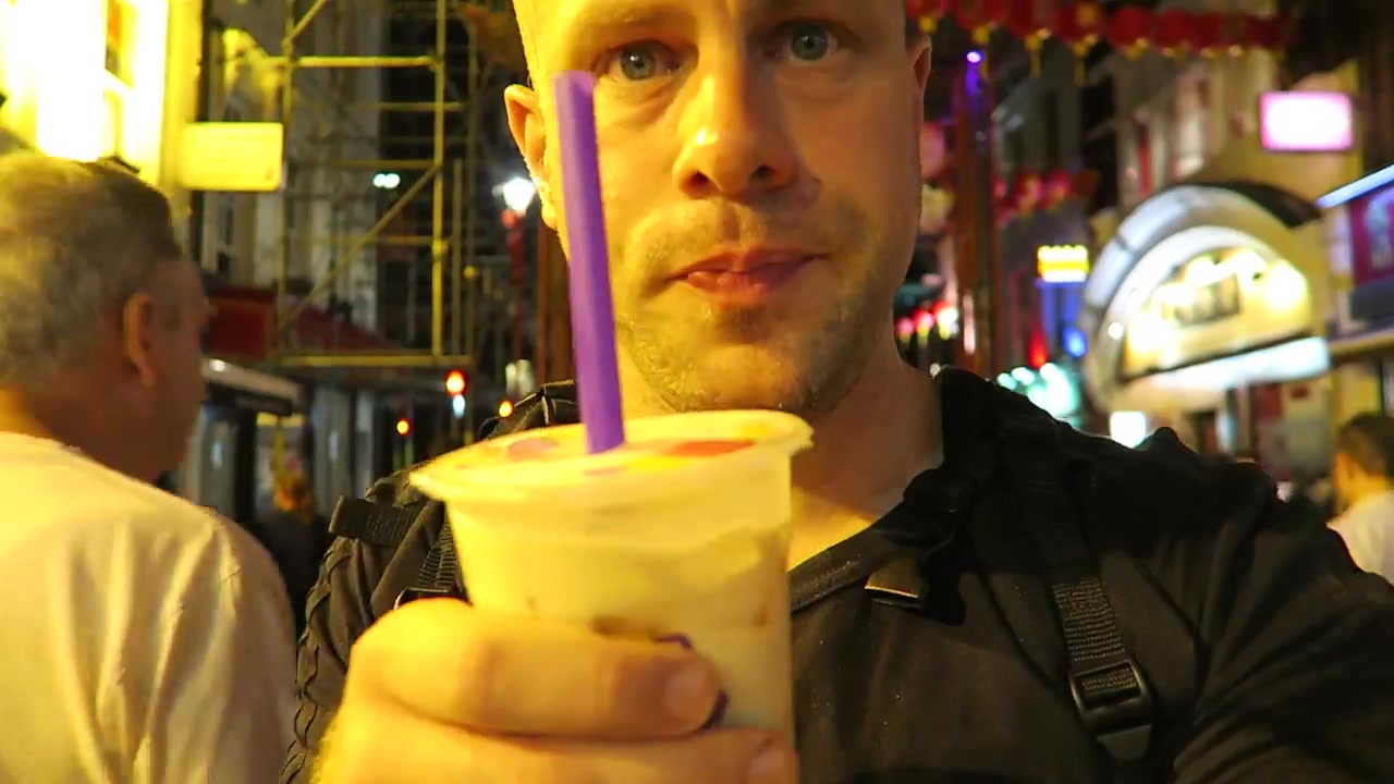 Barry holding bubble tea with a wide purple straw in Chinatown