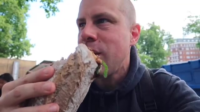 Barry holding a duck confit sandwich with salad at Duke of York Square