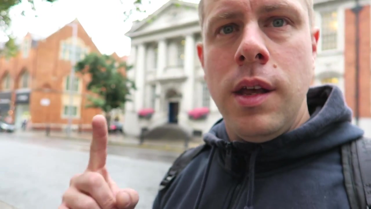 Barry pointing towards the columned entrance of Chelsea Old Town Hall