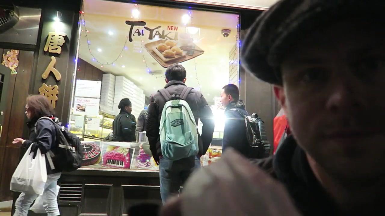 Customers outside Chinatown Bakery beneath a taiyaki sign in the window