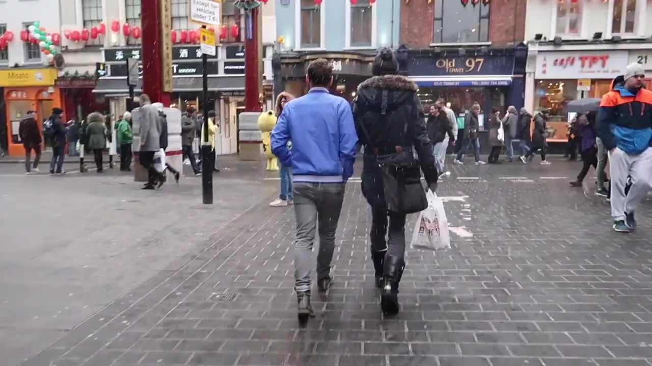 Pedestrians on the snowy walk towards Chinatown.