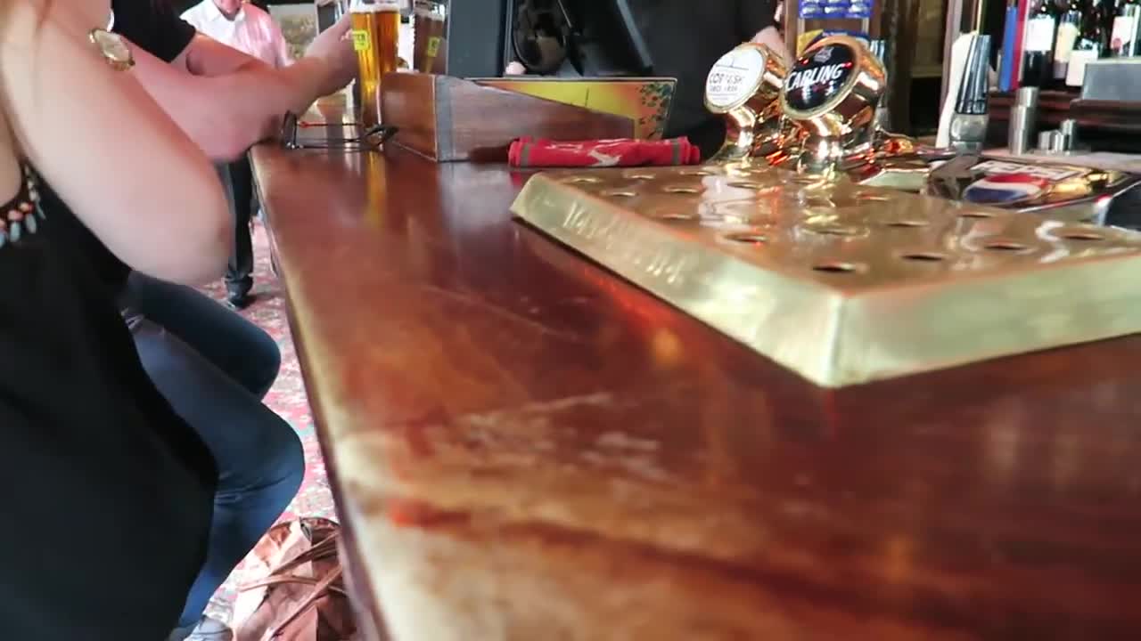 Wooden bar counter and beer pumps inside the Churchill Arms