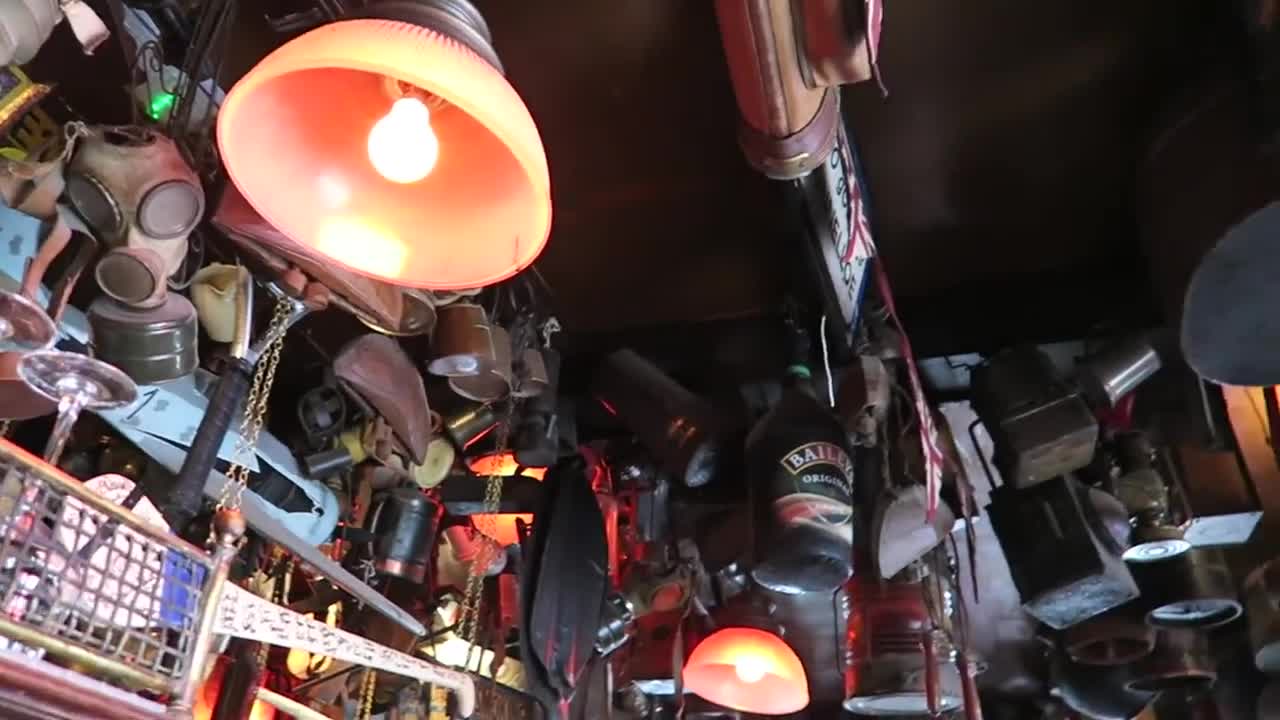 Hanging mugs, memorabilia and red lamps inside the Churchill Arms