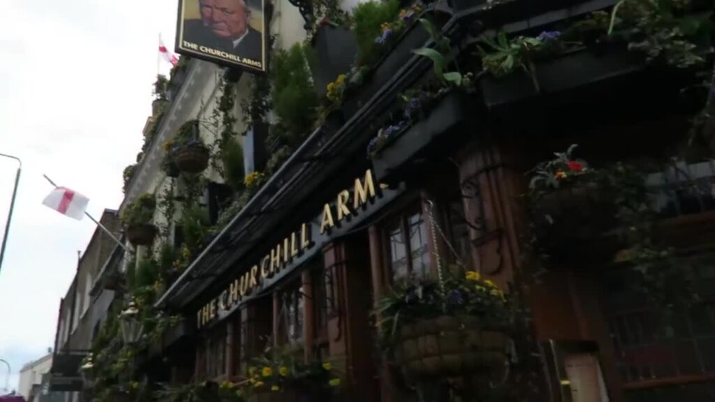 Flower baskets and the Churchill Arms sign above the pub entrance