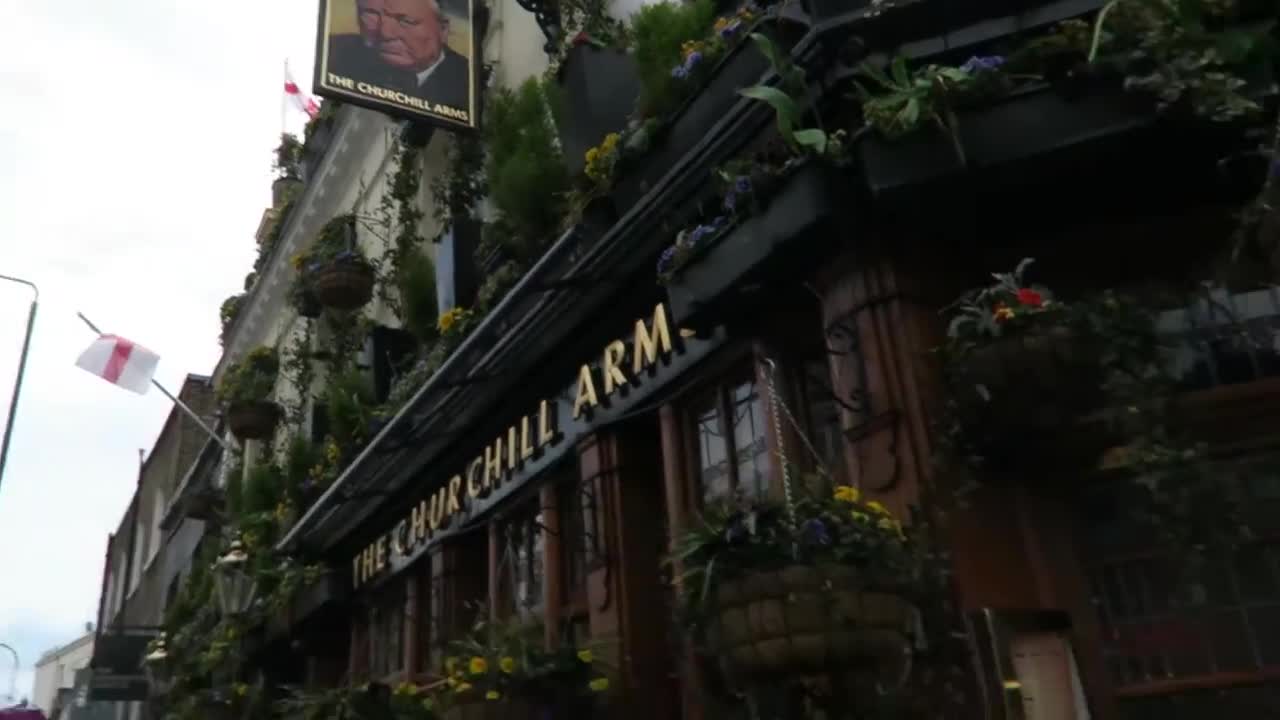 Flower baskets and the Churchill Arms sign above the pub entrance
