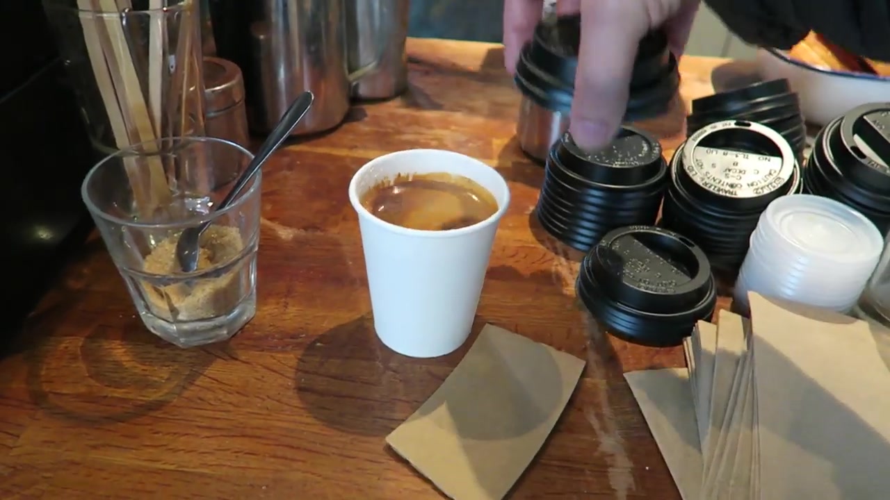 Black Americano in a takeaway cup on the wooden counter at Climpson and Sons