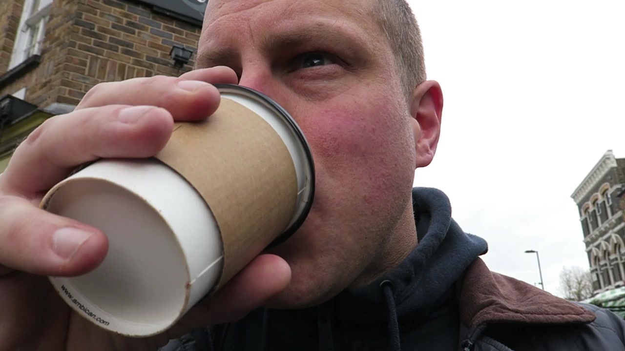 Barry tasting his takeaway coffee among the Broadway Market stalls