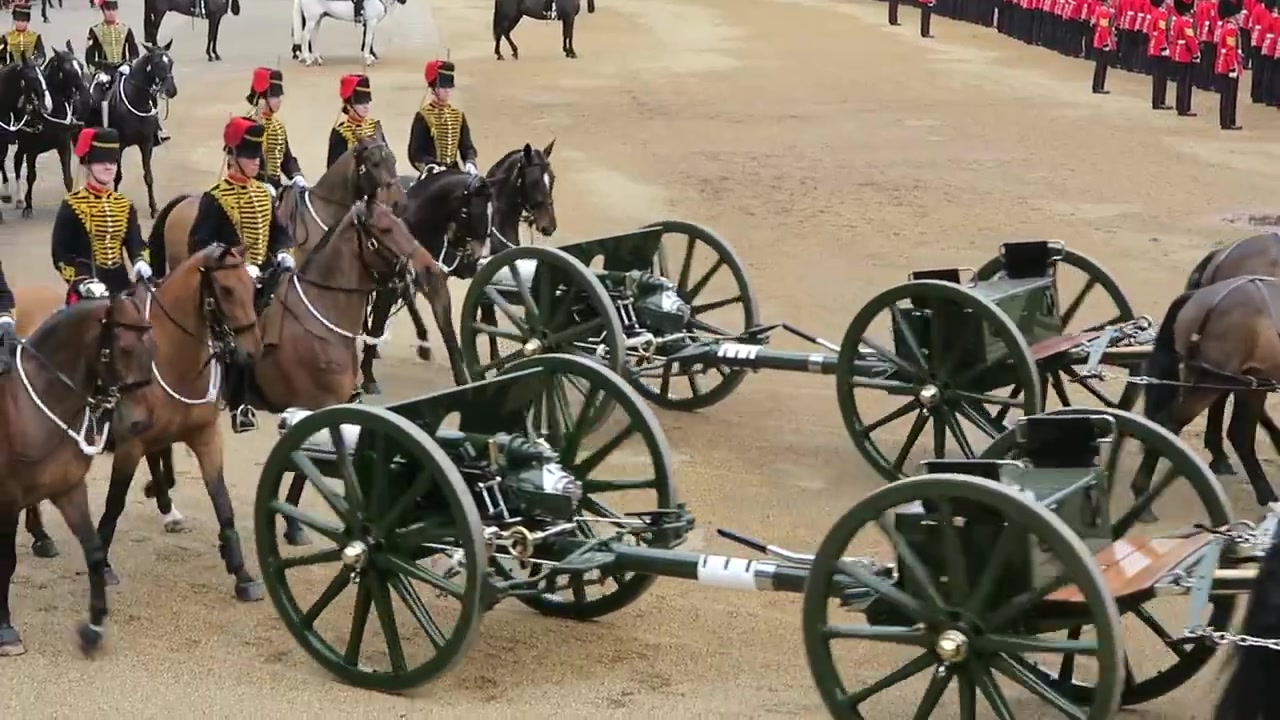 Horse teams pulling green artillery carriages across Horse Guards Parade