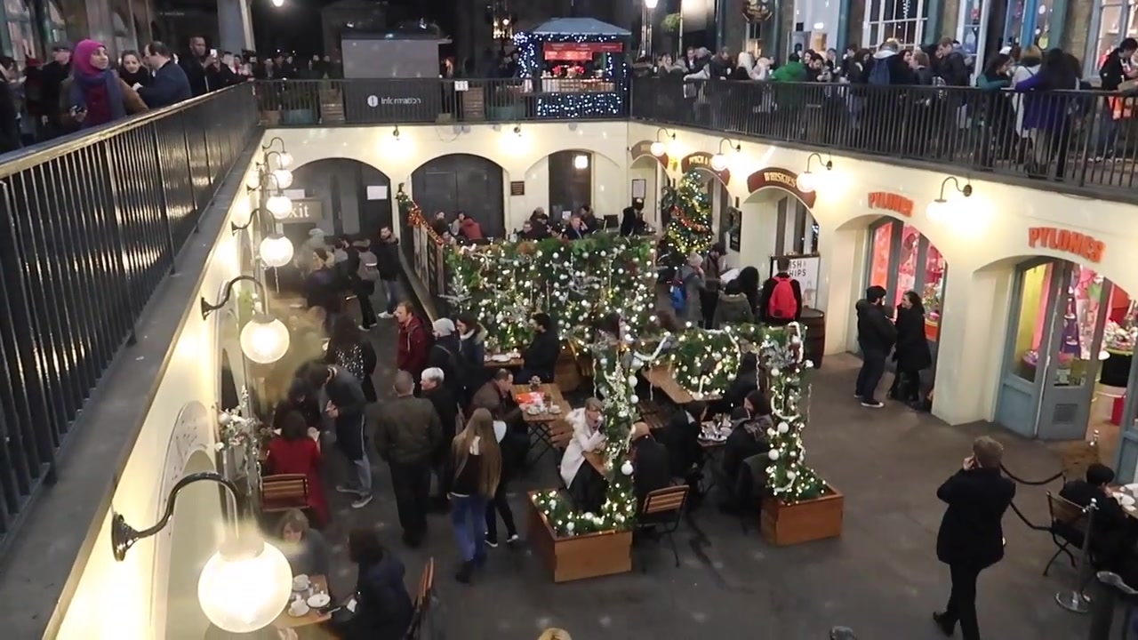 Visitors in the lower courtyard beneath the market’s Christmas decorations.