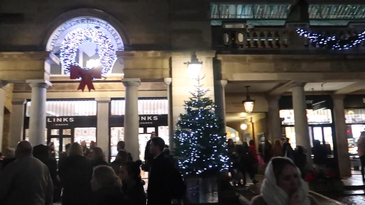Christmas garlands and a large illuminated decoration above the market entrance.