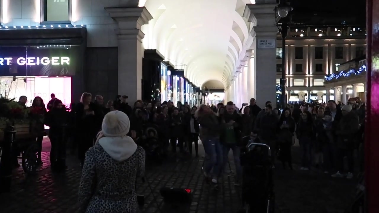 Visitors beneath the bright arches beside Covent Garden Piazza