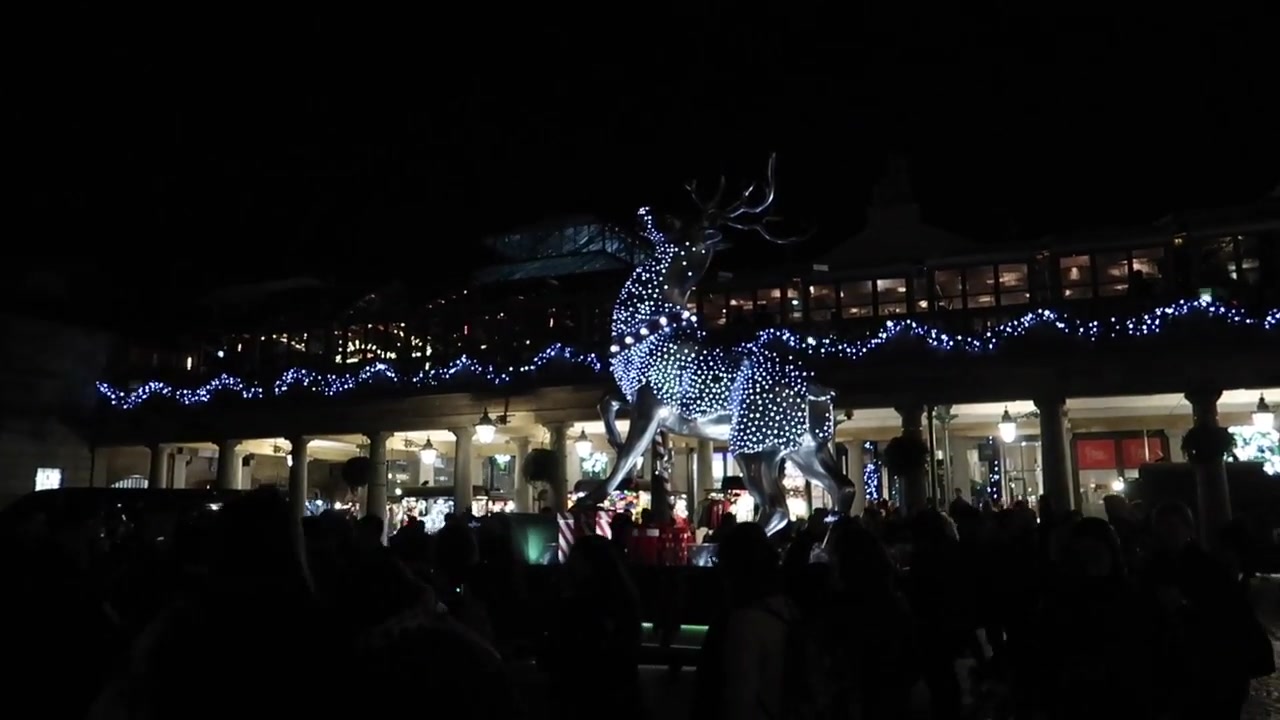Illuminated reindeer above visitors on the East Piazza in Covent Garden