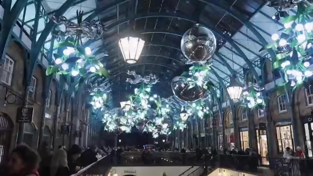Silver baubles and mistletoe chandeliers beneath Covent Garden Market’s roof