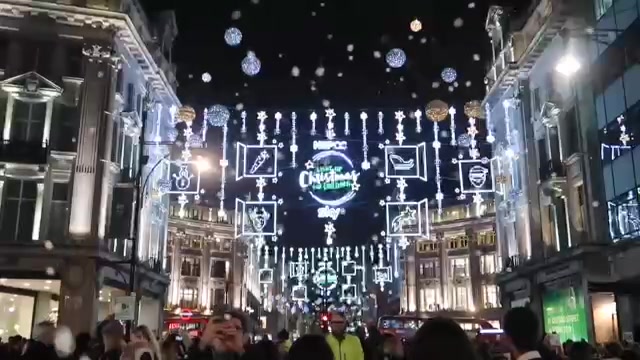 Christmas lights suspended above crowds on Oxford Street at night