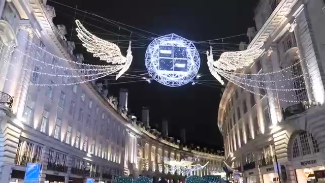 Illuminated angels stretching across Regent Street between curved buildings