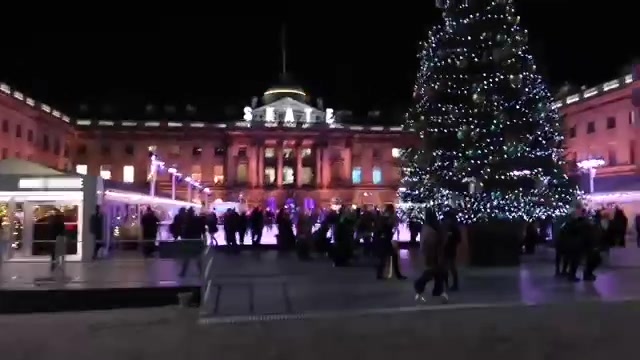 Skaters and a Christmas tree in the illuminated Somerset House courtyard