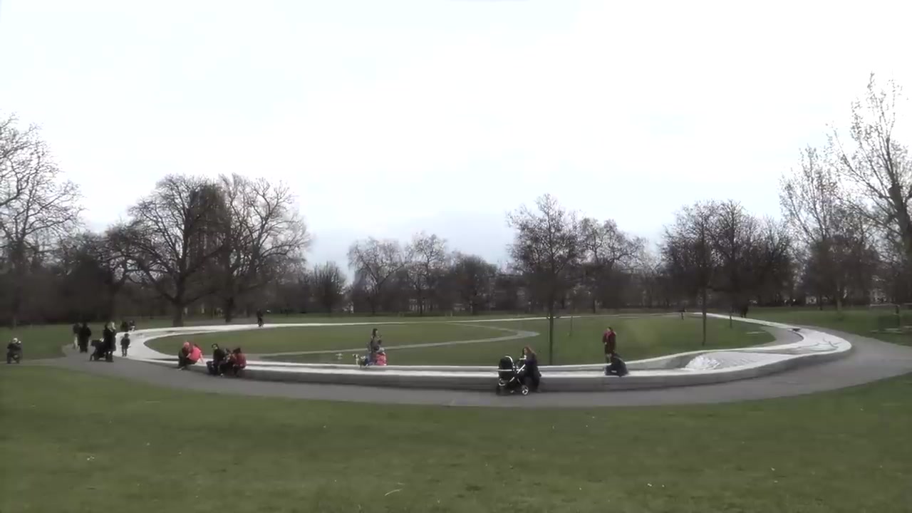 Visitors gather beside the curved watercourse of the Diana Memorial Fountain.