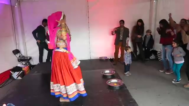 Dancer in a colourful skirt performing inside a Diwali festival tent