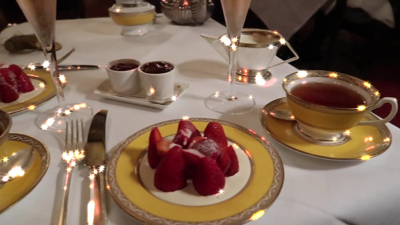 Tea, strawberries and glasses of rosé Champagne on the afternoon tea table.