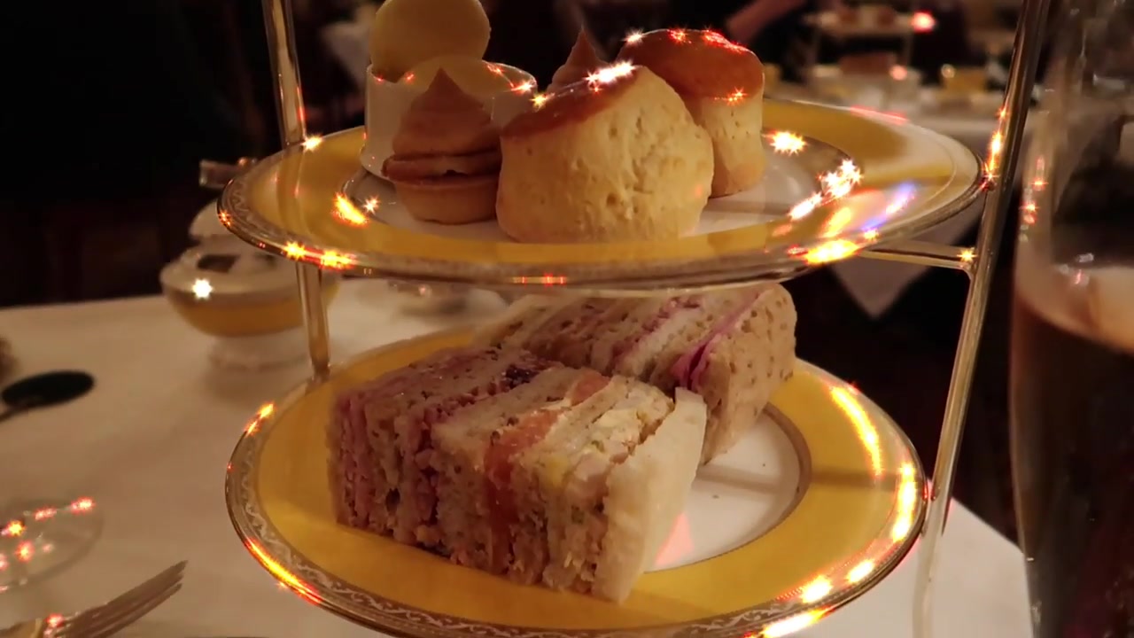 Finger sandwiches and small pastries arranged on the tiered afternoon tea stand.