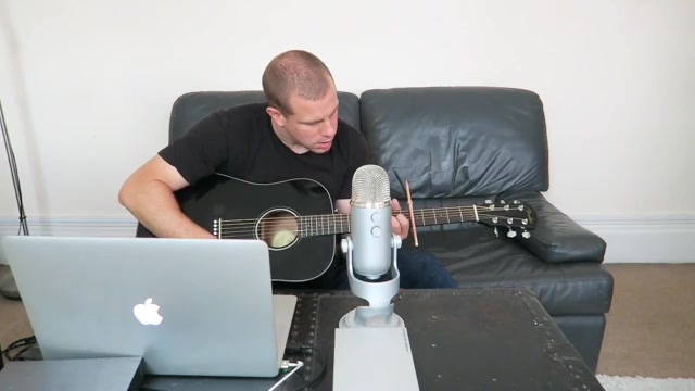 Barry playing acoustic guitar with a laptop and microphone