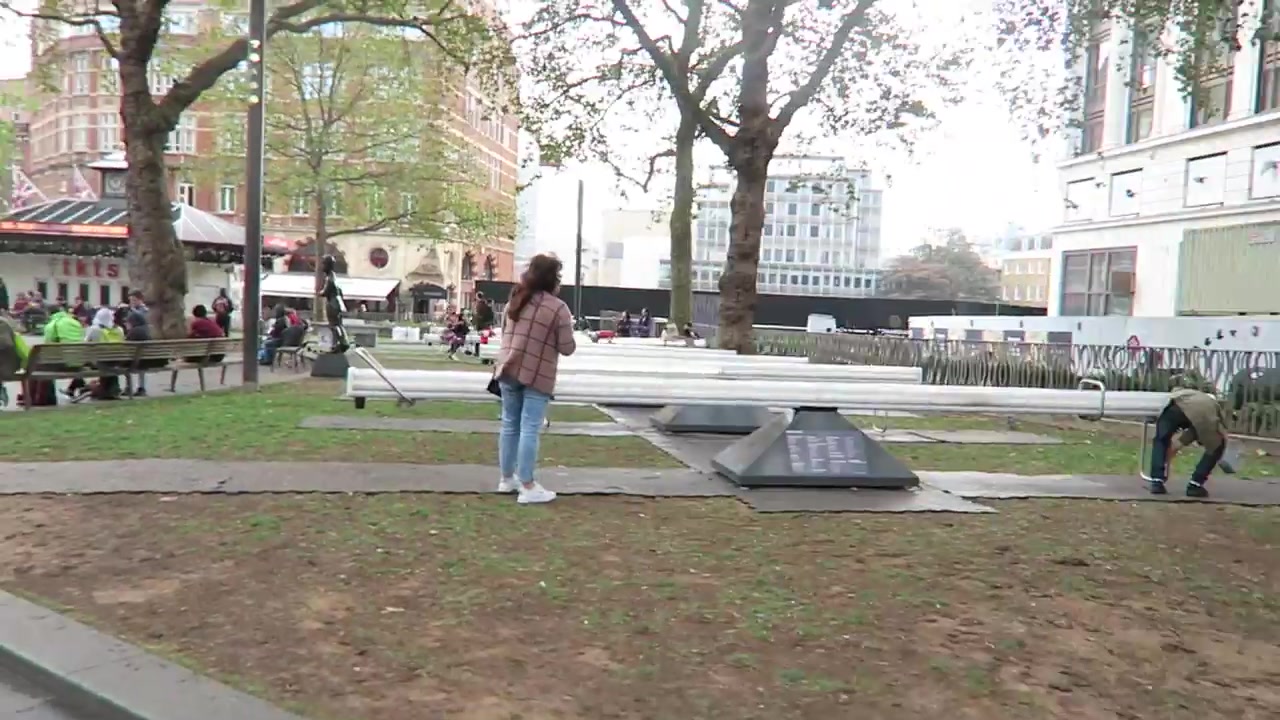 Visitors beside the Impulse Leicester Square seesaws arranged in rows in the gardens