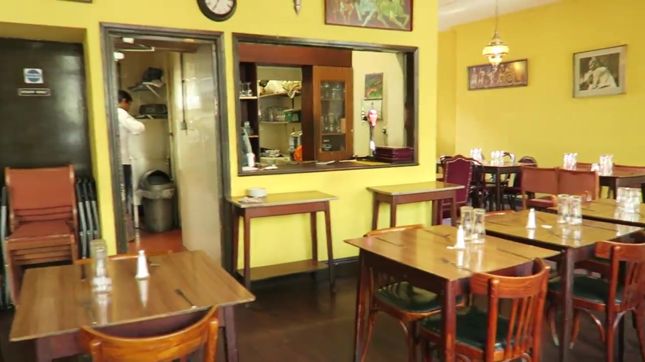 Wooden dining tables and service hatch in the India Club restaurant