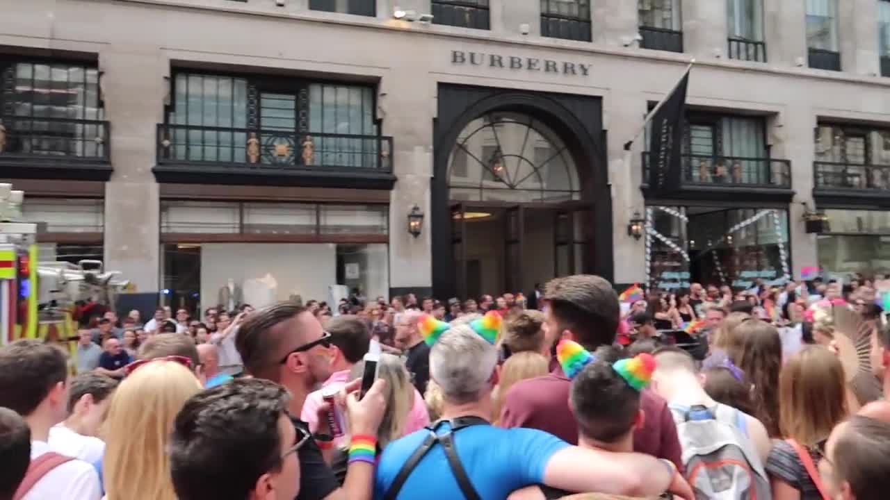 Crowds with rainbow flags watching the Pride parade outside Burberry