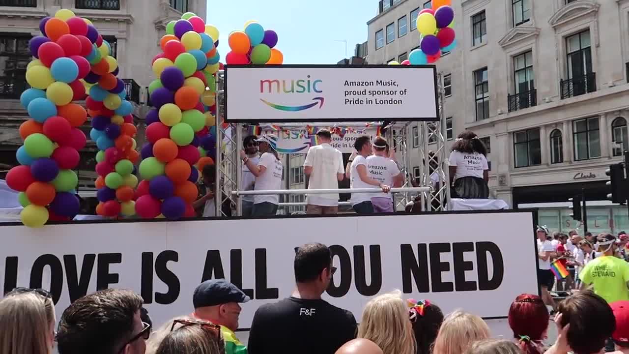 Rainbow balloons and a Love Is All You Need float at Pride in London
