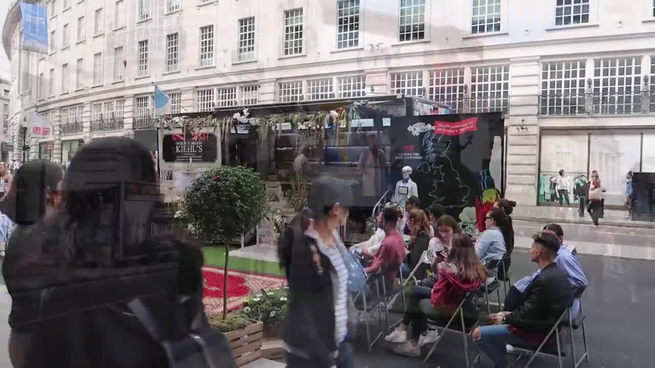 Visitors sitting on a temporary lawn at Regent Street Summer Streets