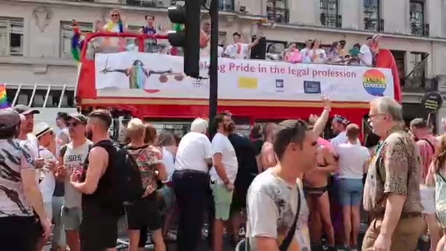 Parade participants and a decorated bus at Pride in London 2018