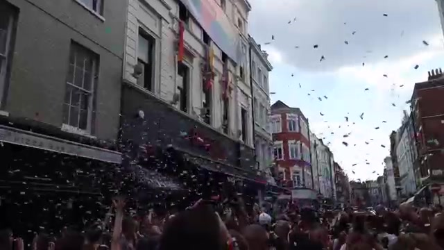 Crowds beneath floating confetti during Pride in London 2018