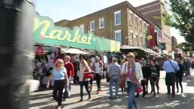 Crowds walking past the large Camden Market sign on a sunny day in 2016