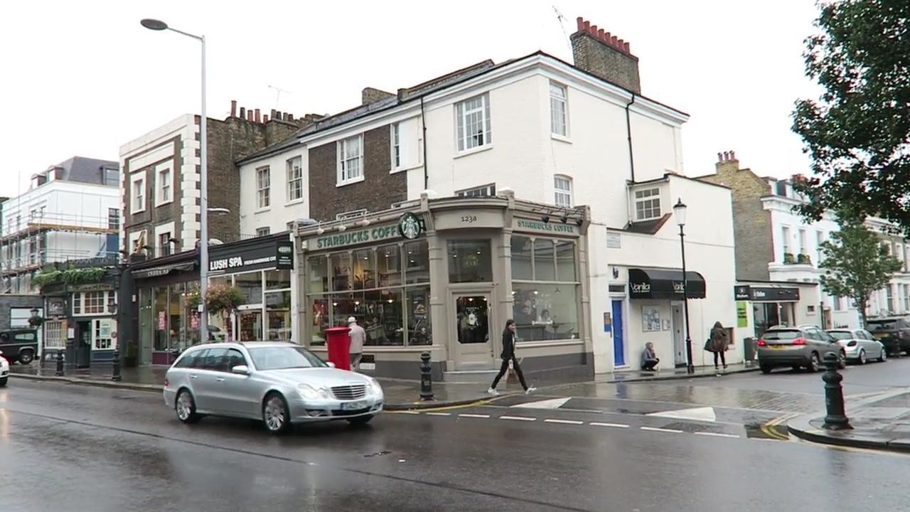 King’s Road shops, traffic and wet pavement during the Chelsea walk