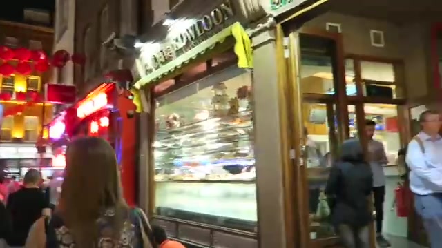 Illuminated Kowloon bakery window on a Chinatown street at night