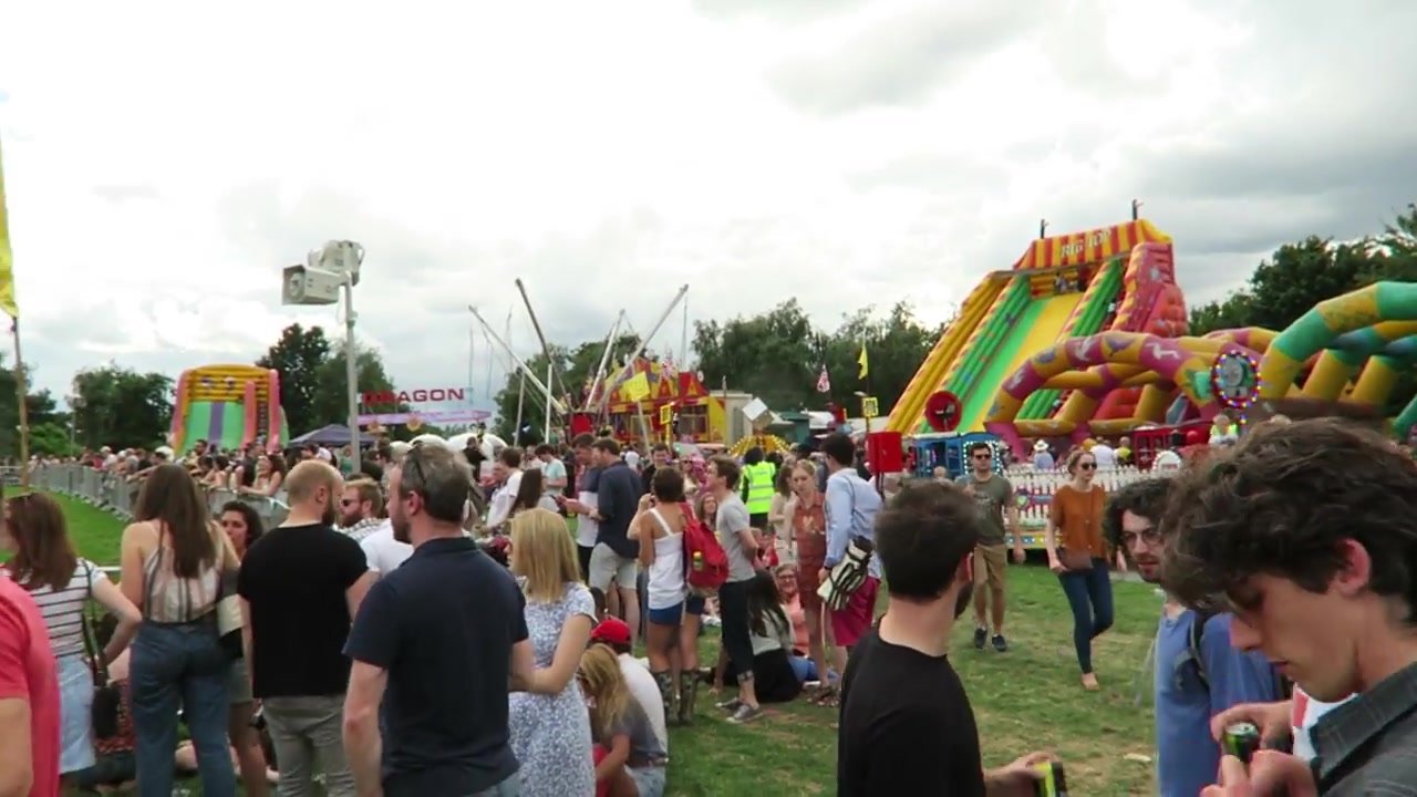 Crowds beside colourful slides and fairground attractions in Brockwell Park