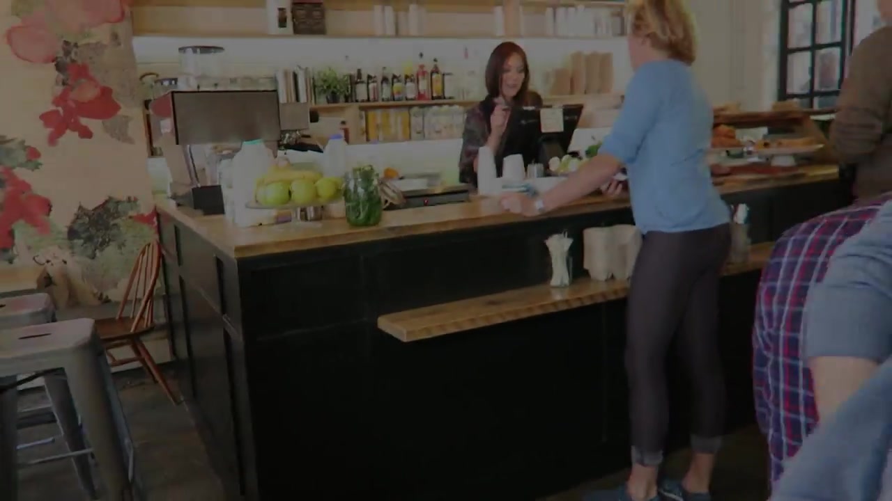 Coffee counter with cups and customers inside Lantana Camden