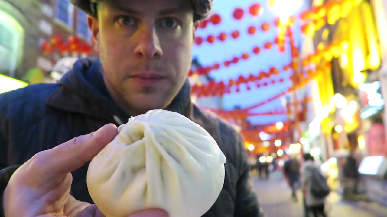 Barry holding a large steamed Baozi Inn pork bun in Chinatown in 2016