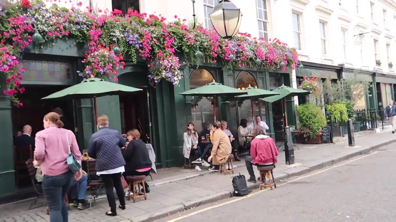 Hanging baskets and outdoor tables at the Warwick Castle pub.