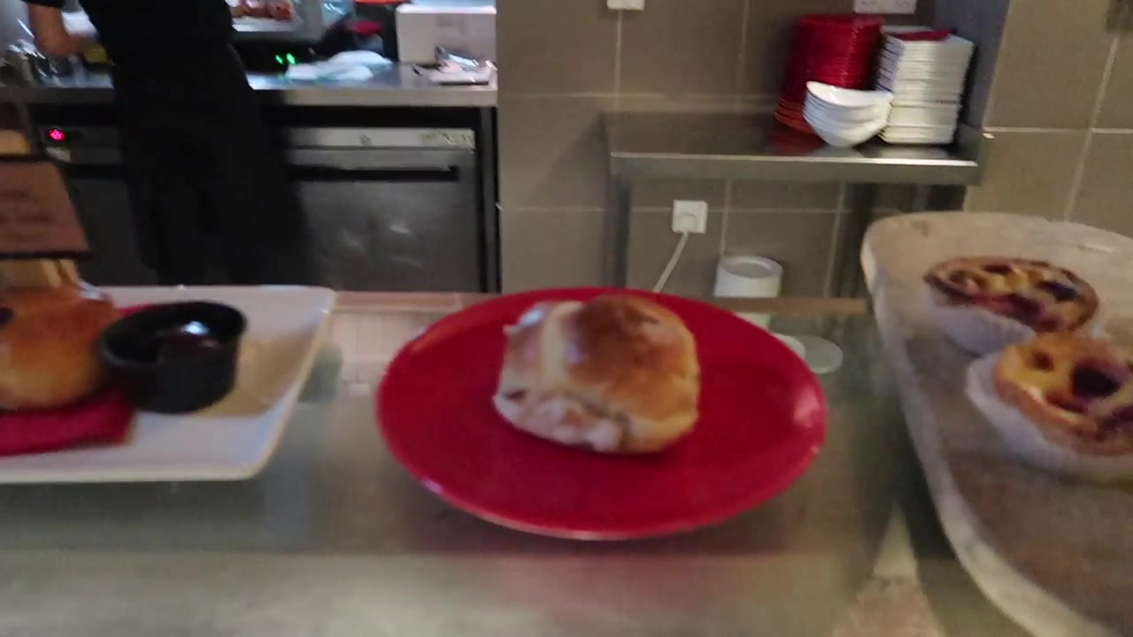 Hot cross bun served on a red plate at the Café in the Crypt