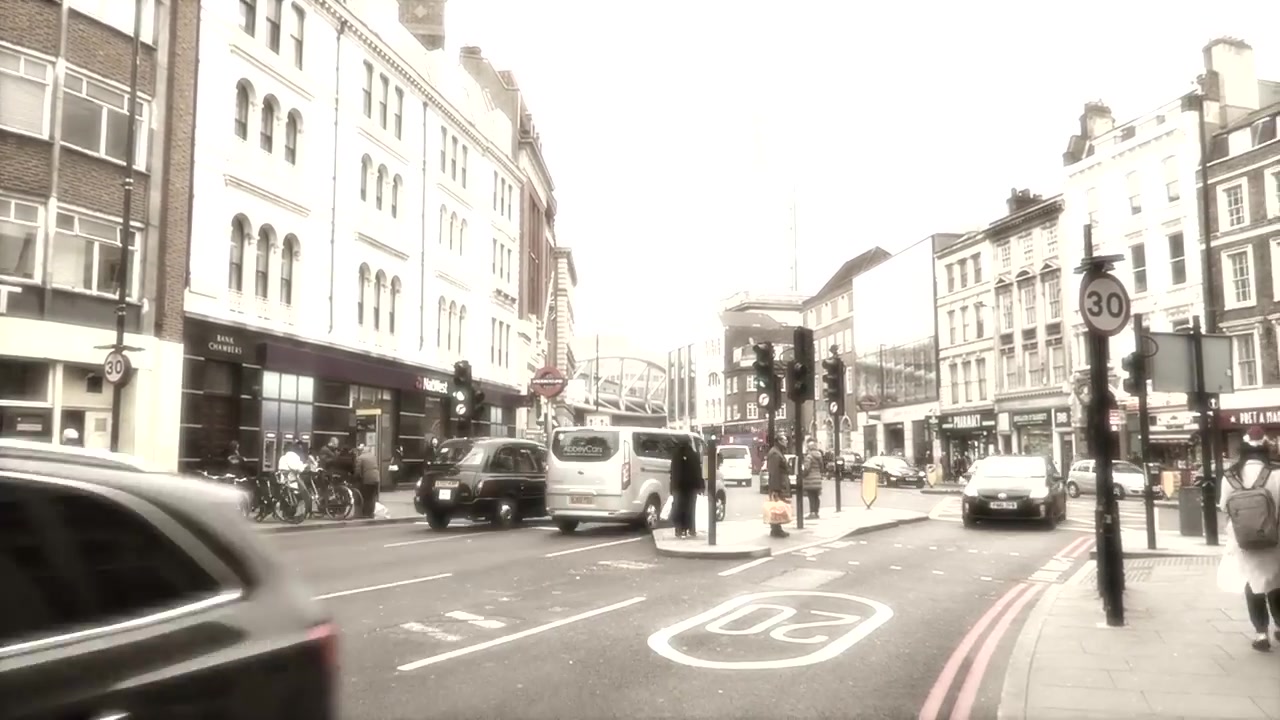 Traffic and pedestrians on a London street in the closing montage