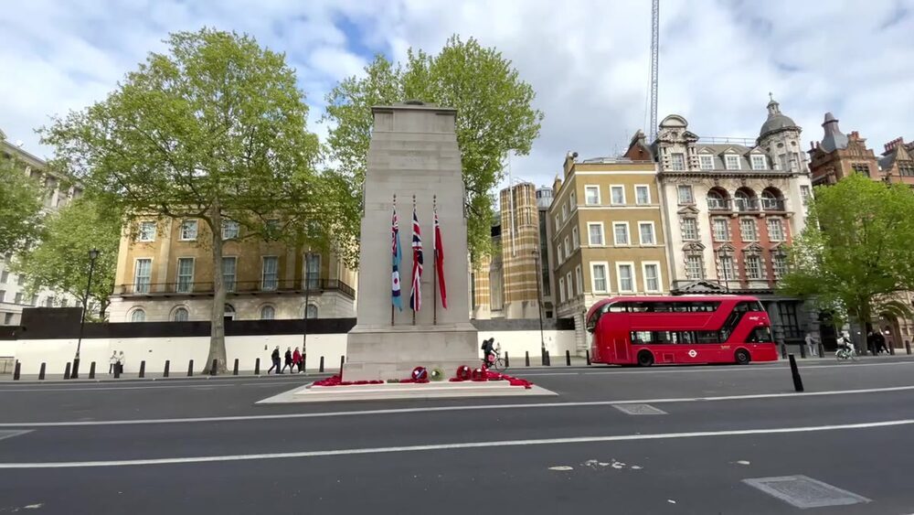 The Cenotaph memorial on Whitehall with a red London bus