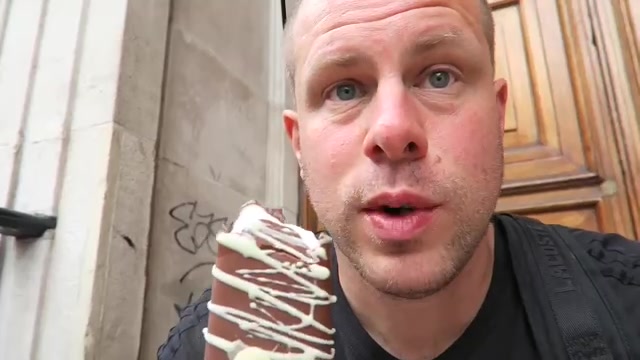 Barry Roberts holding a chocolate-coated Magnum with white drizzle