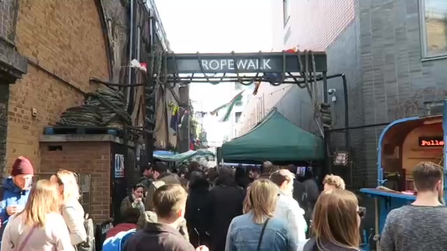 Visitors beneath the Rope Walk sign at Maltby Street Market
