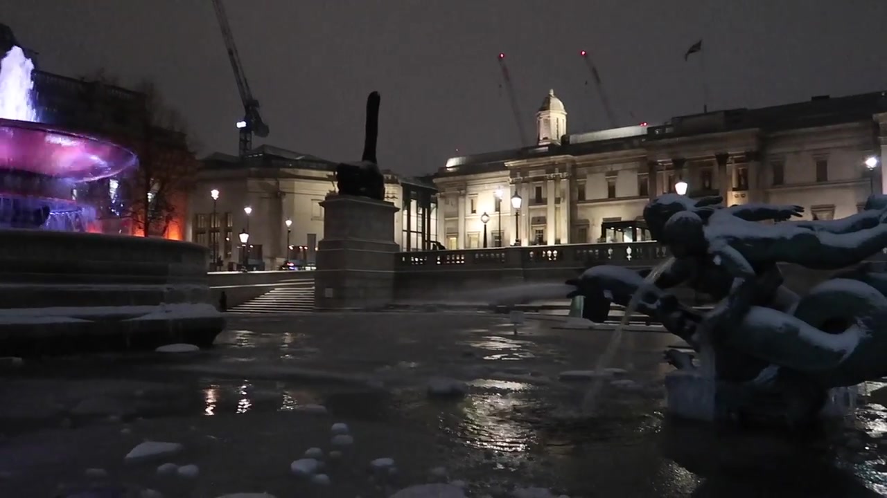 The illuminated fountain and National Gallery during the snowy walk.